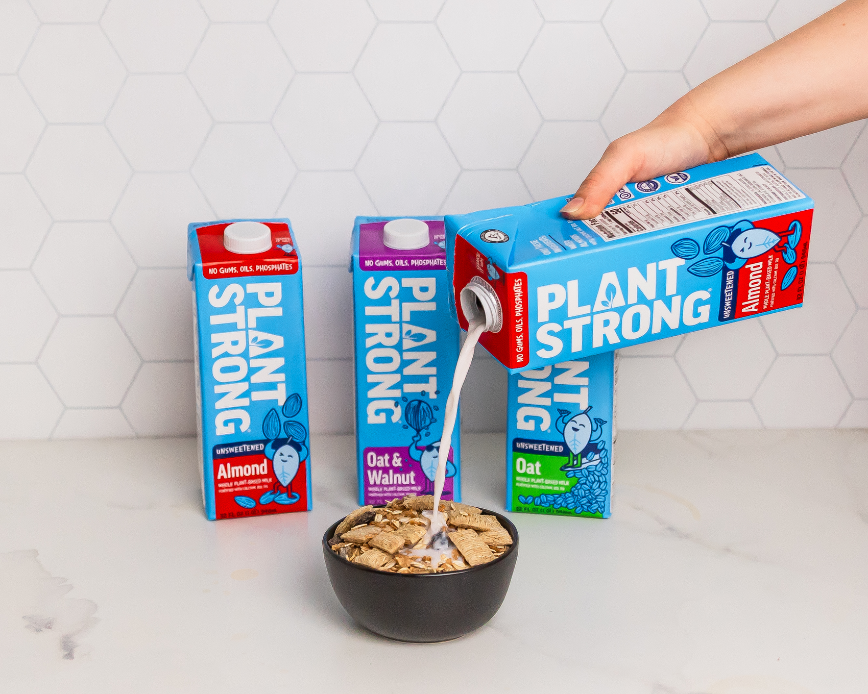 Person pouring Plant Strong milk into a bowl of cereal with multiple cartons in the background.